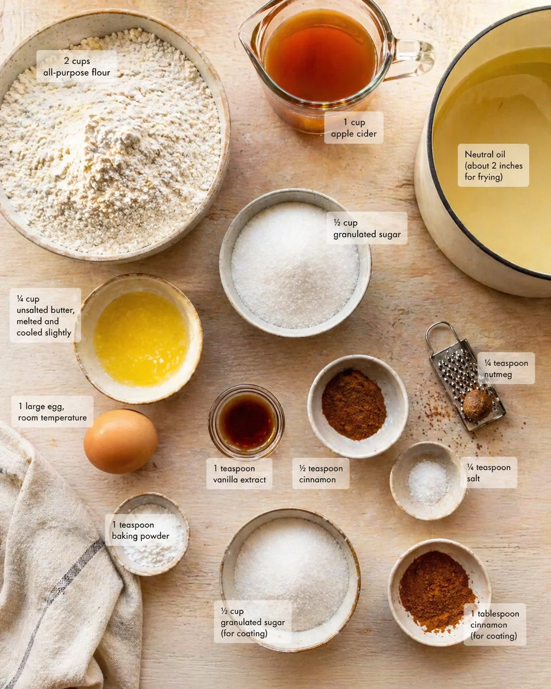Measured ingredients arranged for Irresistible Apple Cider Donuts With Cinnamon Sugar Crust: 2 cups all-purpose flour (spooned and leveled, no packing!), 1 cup apple cider (we’ll reduce it to ½ cup for maximum flavor—fre