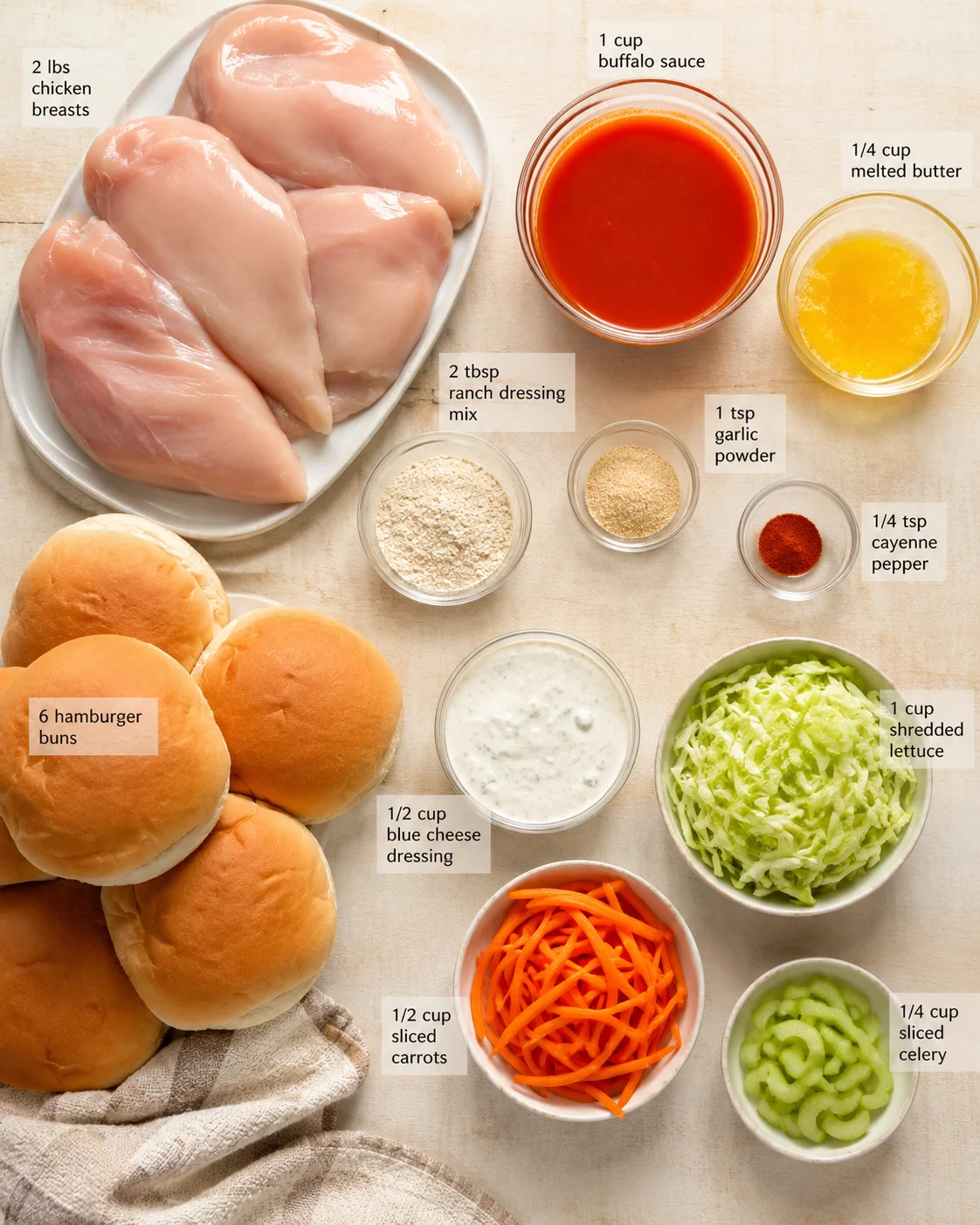 Top-down view of chicken breasts, hamburger buns, lettuce, carrots, celery, and labeled sauce bowls.