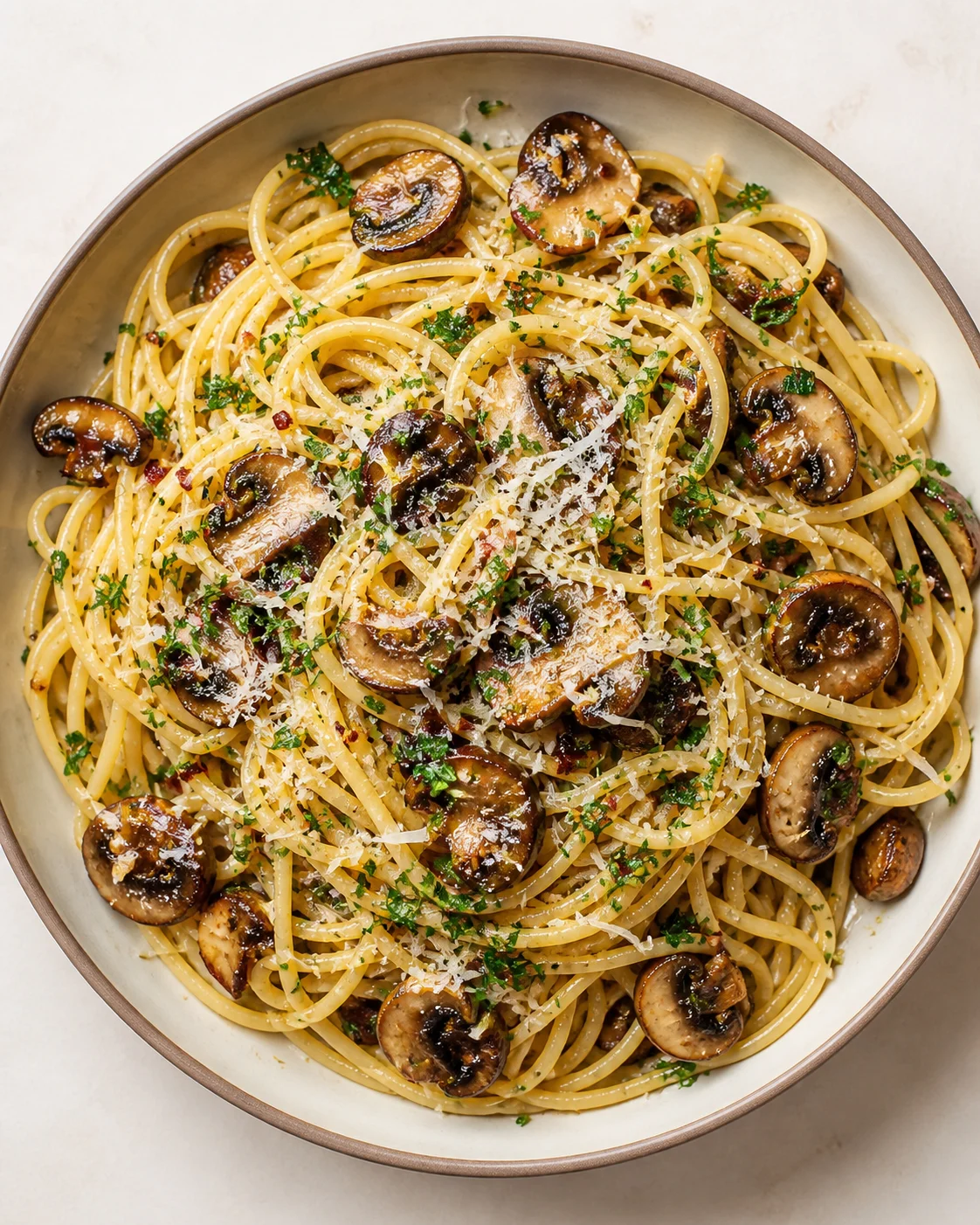 bowl of creamy mushroom linguine topped with parmesan and parsley