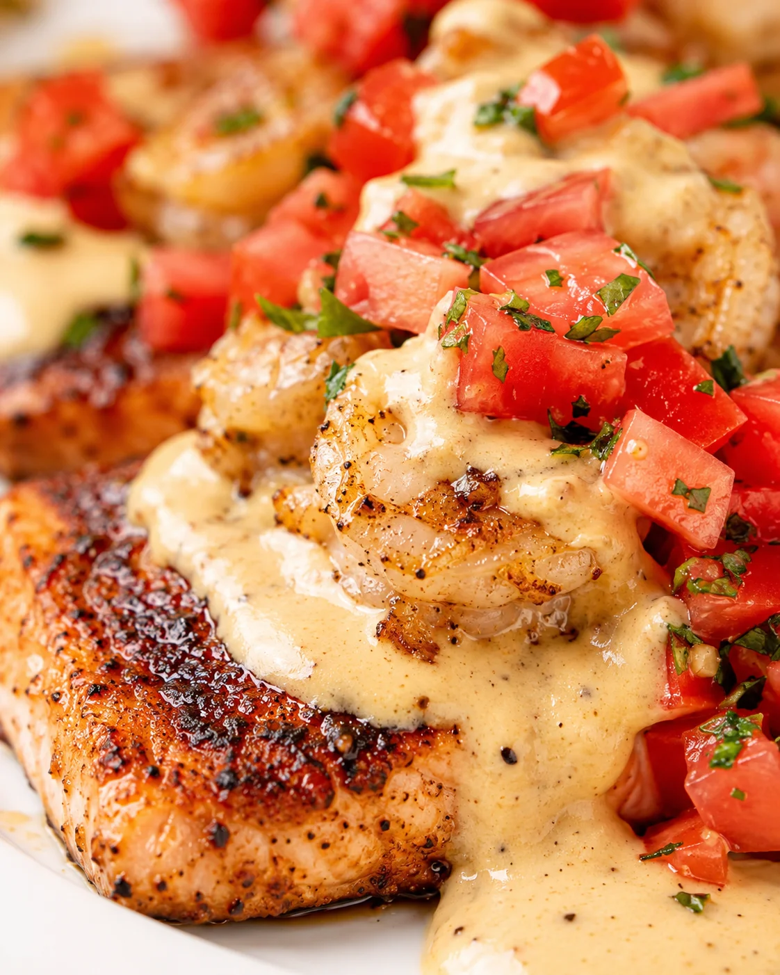 Seared chicken breast topped with creamy sauce and tomato-herb salsa.
