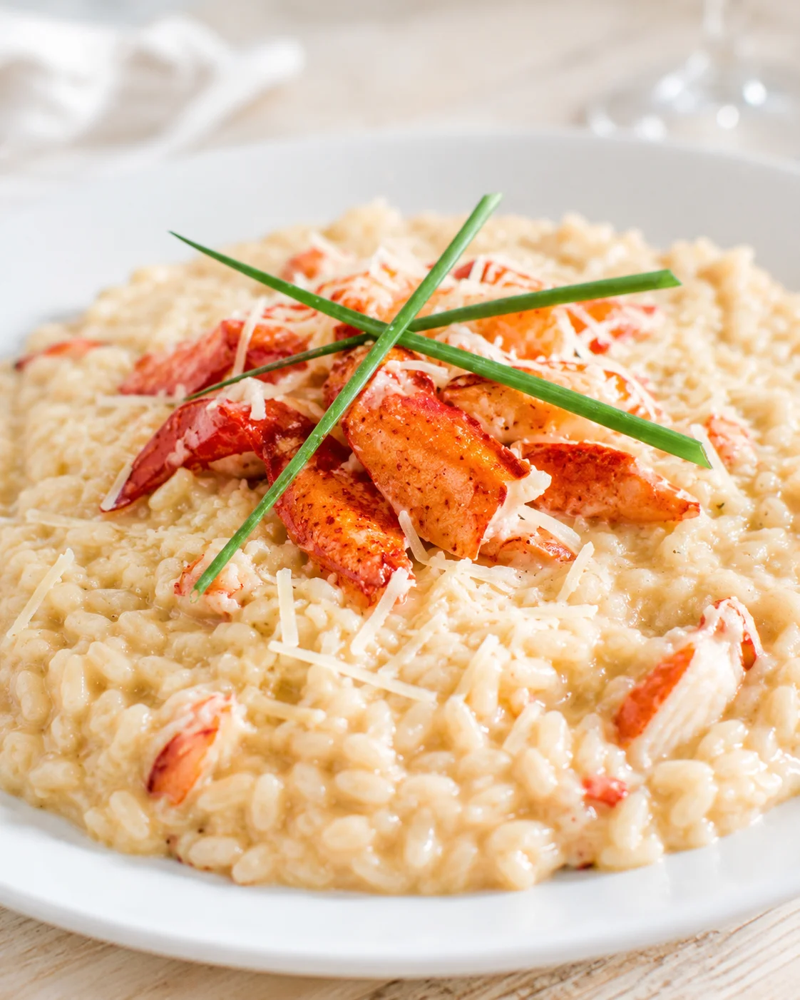 creamy lobster risotto topped with orange lobster chunks and chives