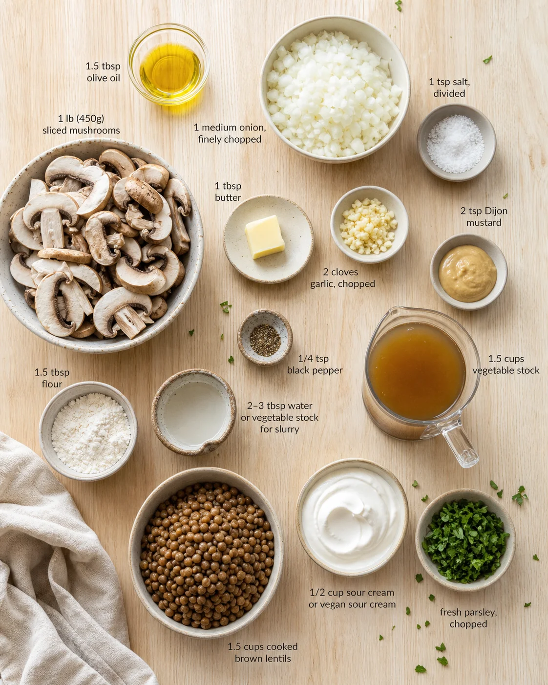 top-down view of mushrooms, onions, oils, and spices arranged with labels on a wooden kitchen table