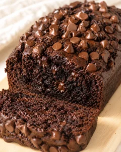 dense chocolate loaf cake studded with glossy chocolate chips, sliced to show moist crumb