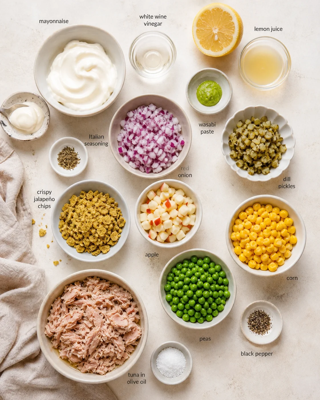 Top-down layout of labeled ingredients for tuna salad, including tuna, vegetables, fruits, and condiments.