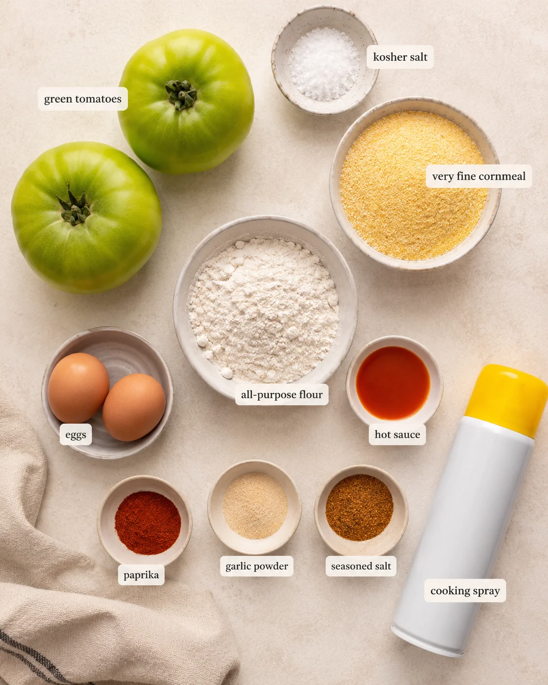 Arrangement of ingredients for crispy air fryer fried green tomatoes, including tomatoes and seasonings.