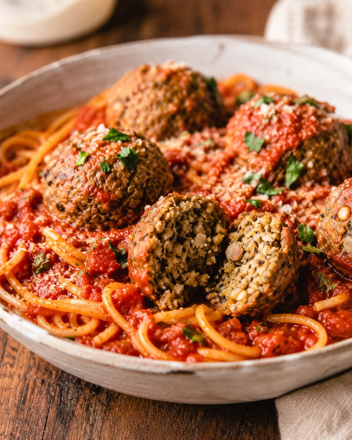 Eggplant Meatballs with Mushrooms and Garlic Close-up of vegetarian eggplant and mushroom meatballs served with spaghetti and tomato sauce.
