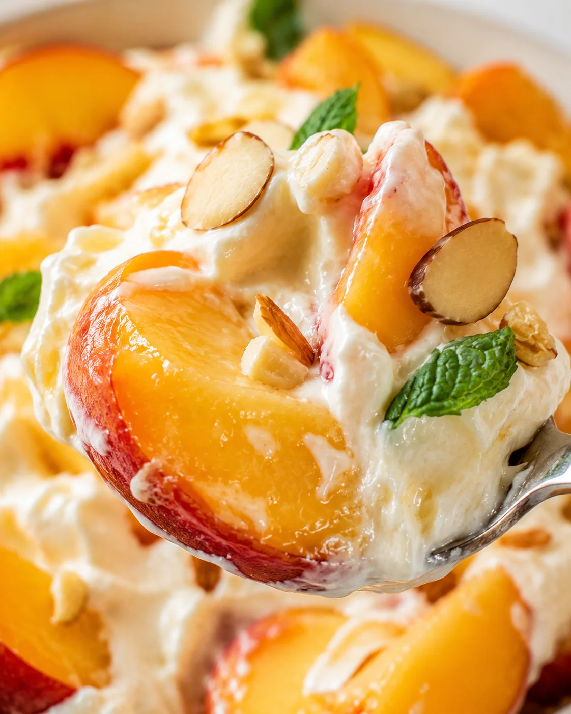 Peaches and Cream Salad Delight Close-up of a fresh peaches and cream salad with almonds and mint.
