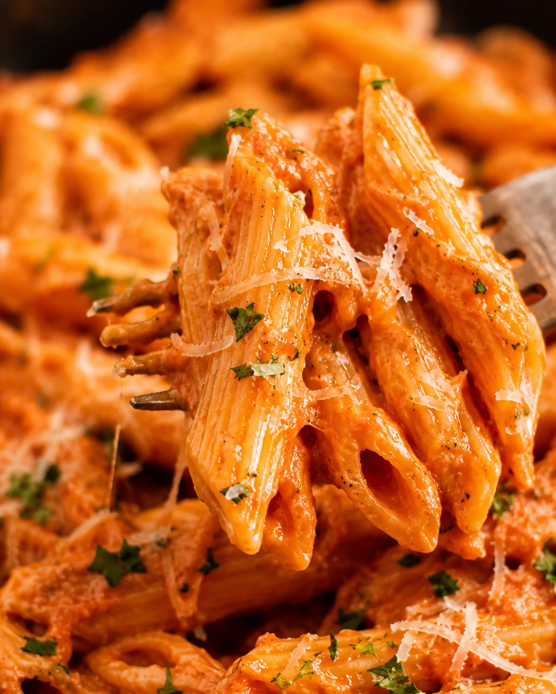Close-up of creamy red sauce pasta with herbs and grated cheese