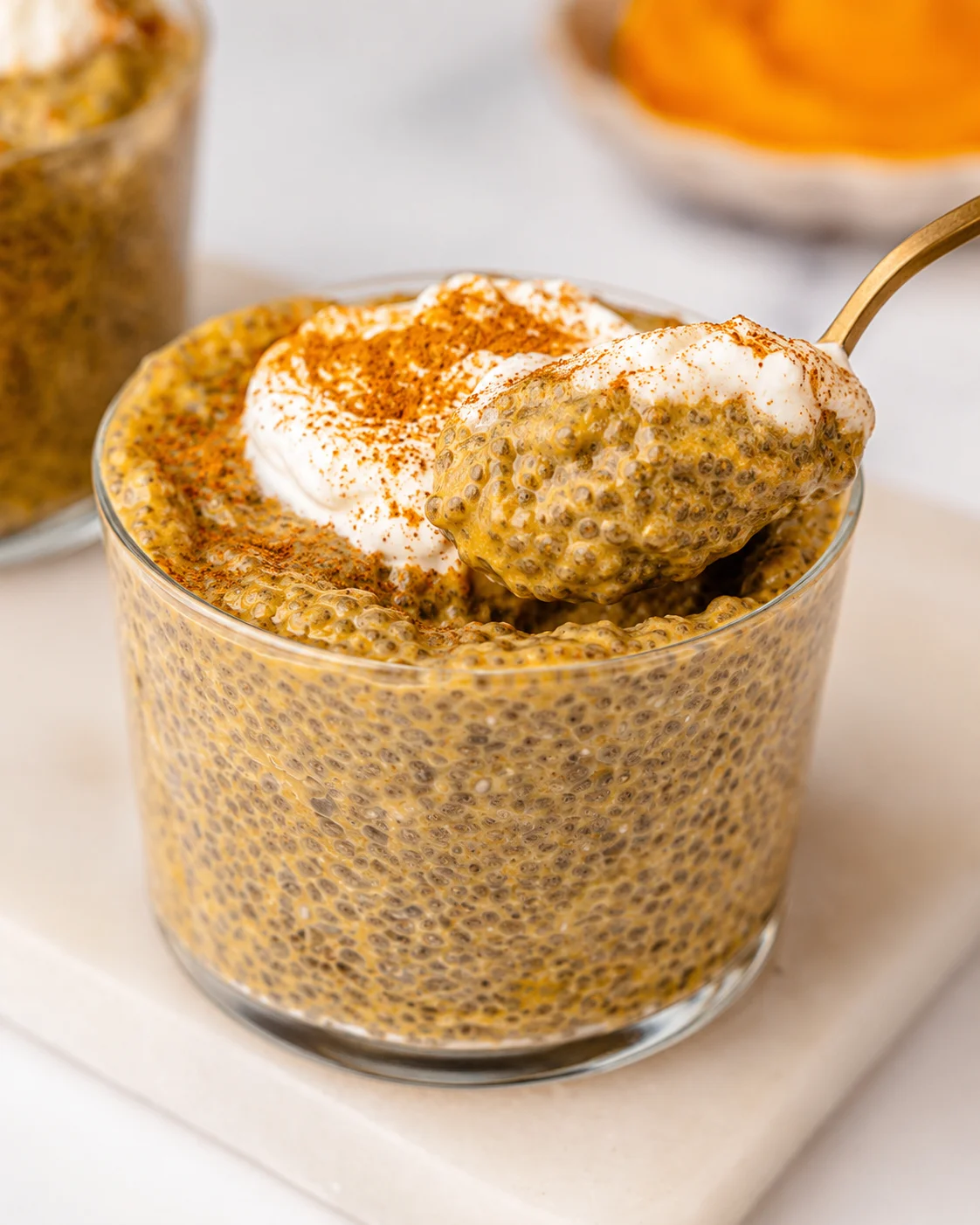 Creamy pumpkin chia pudding topped with whipped cream and spices