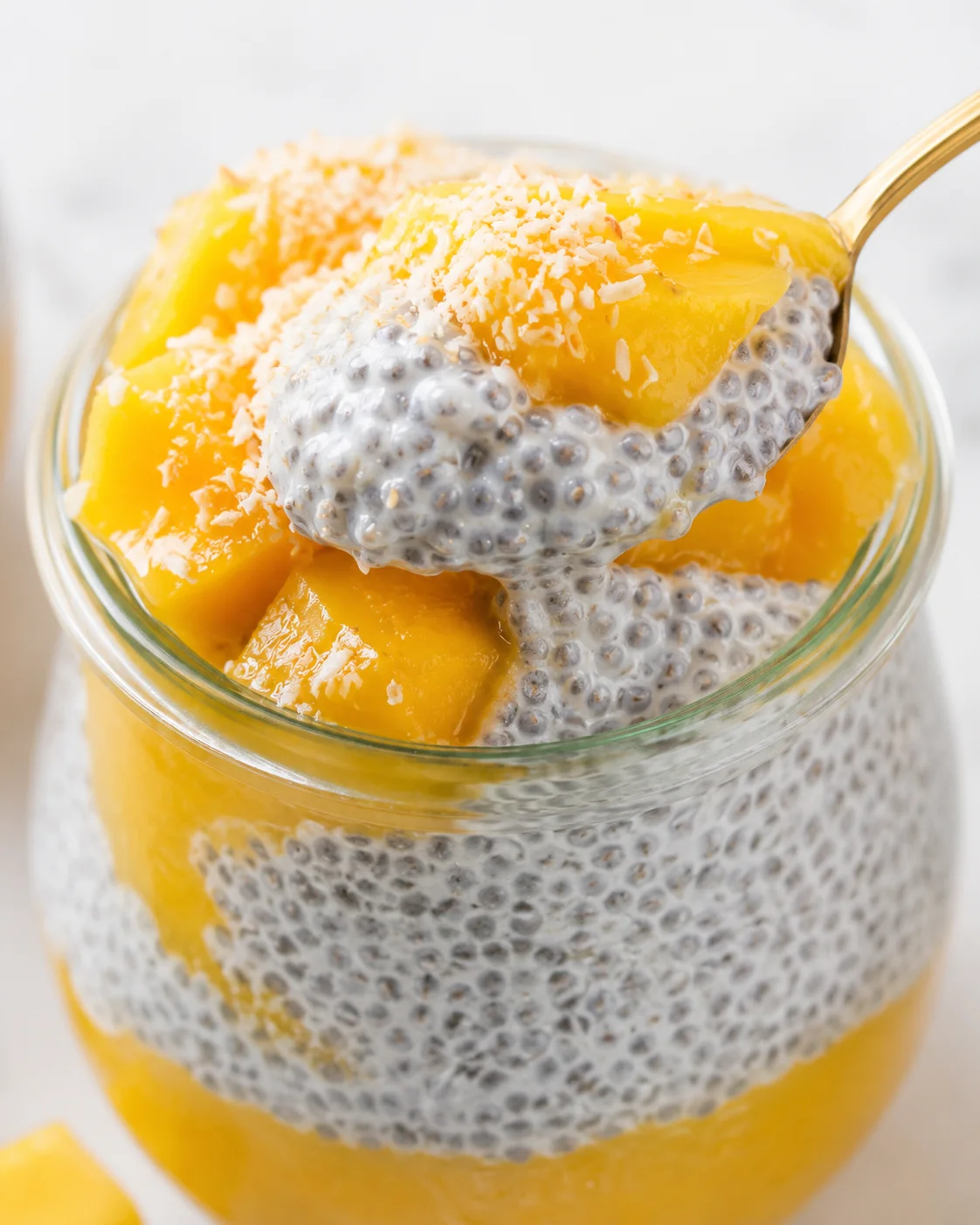 Delicious mango chia pudding topped with shredded coconut in a glass jar