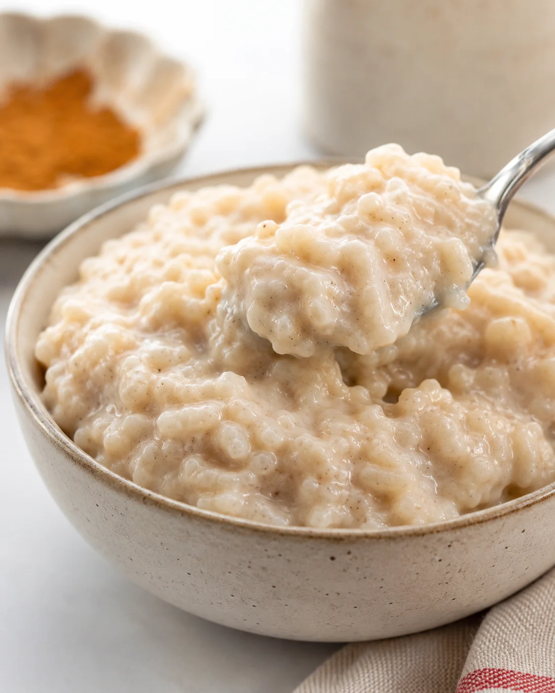 Creamy Slow Cooker Rice Pudding A close-up of creamy rice pudding served in a bowl with a spoonful lifted out.